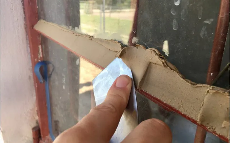 Window glazing with putty and a knife on an old window