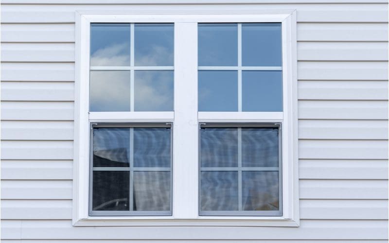 Image of a double hung window against the exterior of a home with vinyl siding
