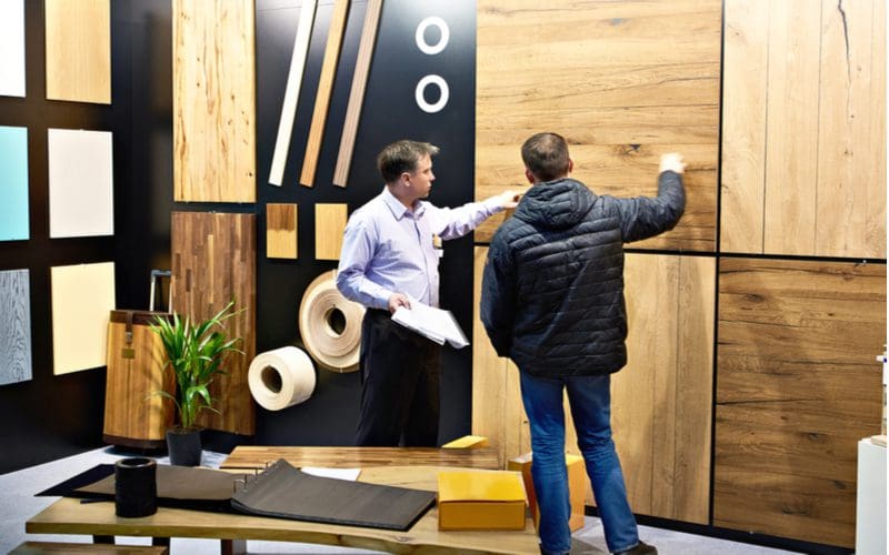 Guy looking at a bunch of bamboo flooring samples in a showroom