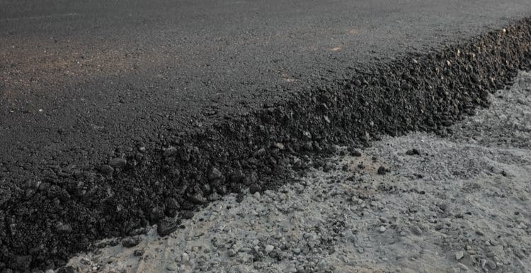 Featured image for a piece on can you pour concrete over asphalt featuring a cutaway of an asphalt road