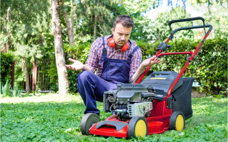 Man holding his hands in the air because his lawn mower won't stay running and he's disappointed in it