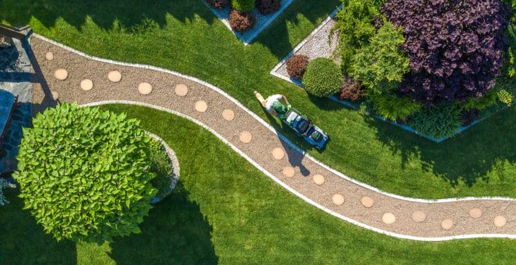 Featured image for a post on landscaping ideas with a guy mowing his extremely green lawn