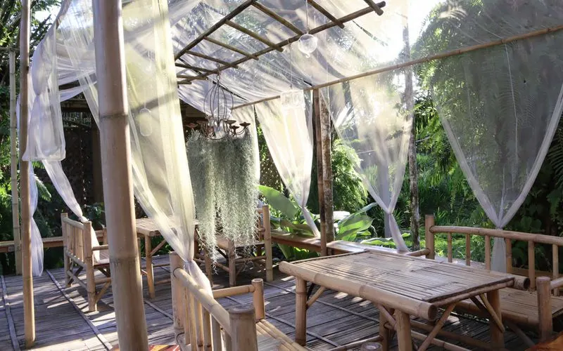 Patio shade idea of bamboo frame holding thin white cloth to shade the sun