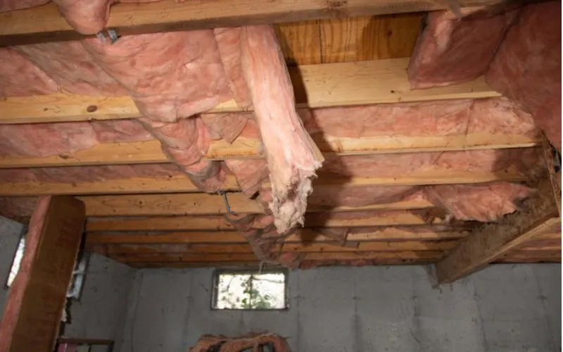 image of insulation in a crawl space hanging down from the rafters