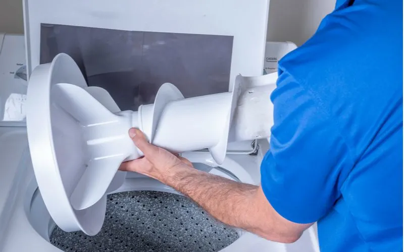 Guy installing a washing machine agitator in a top-loading washer