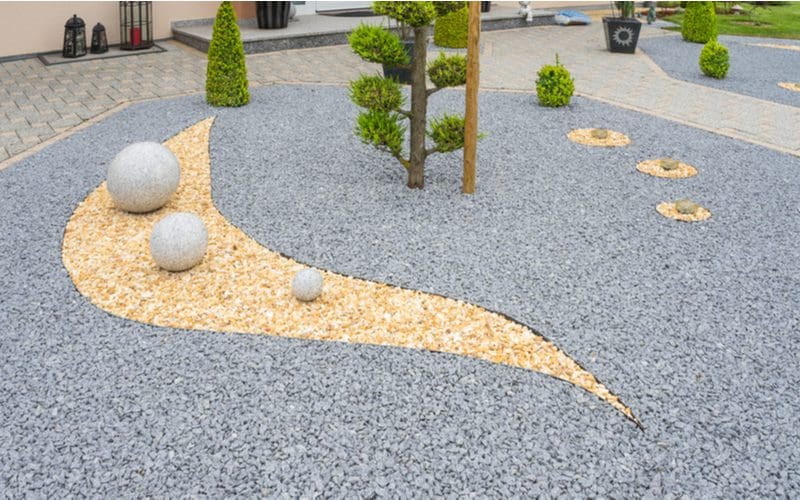 Modern rock garden with two large stone balls alongside simple grey rock with a comma pattern tan rock cluster