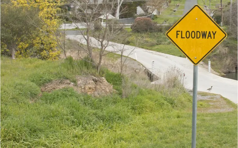 Yellow sign with the words Floodway written in bold lettering next to a road