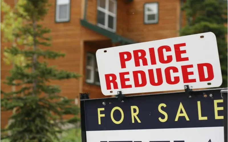 image that says price reduced above a for sale sign for a piece on when is the best time to buy a house