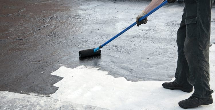For a piece on what is concrete paint, a guy rolling it on a concrete floor