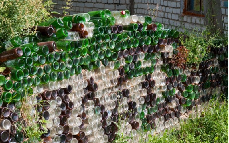 Glass bottle fence made from a bunch of clear, brown, and green bottles