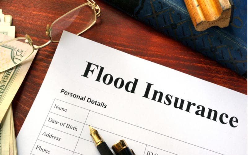 Piece of paper on the table with the title of Flood Insurance for a piece on is my house in a flood plain