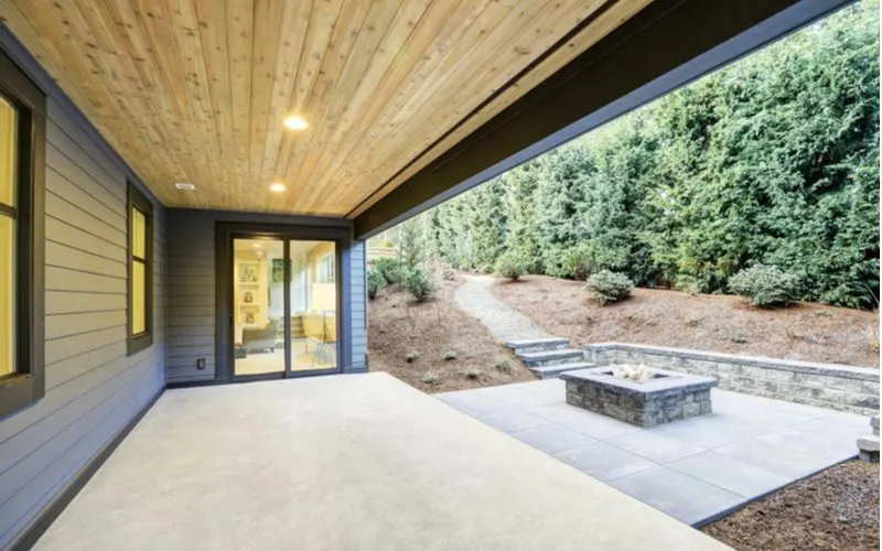 Backyard with a concrete patio under a covered wooden porch