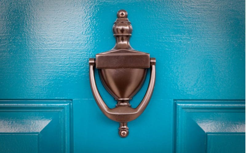 Door knocker on the outside of a teal blue house
