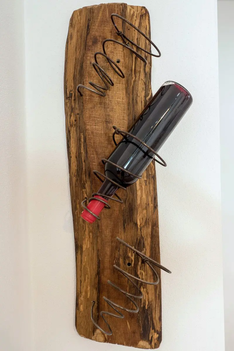 Unique wooden bottle holder with a wine bottle upside down and turned to the side