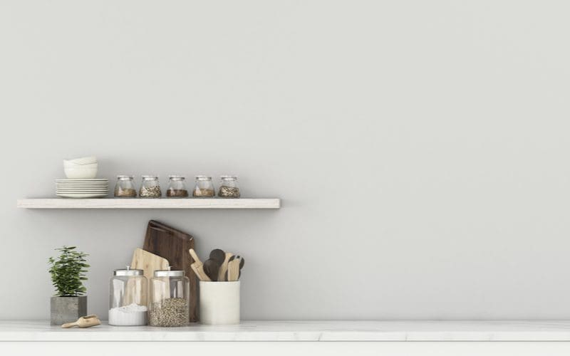 Lean-top bar with floating shelves holding some spices for a piece on basement bar ideas