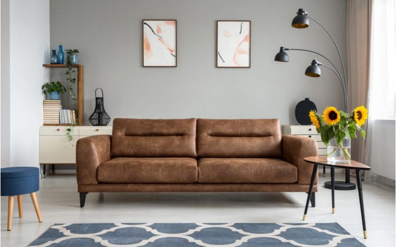 Geometric shaped rug in front of a dark brown couch in a living room