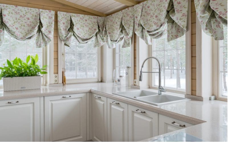 Image showing one of the most popular types of kitchen curtains, a valance, draped over a wraparound window with a view