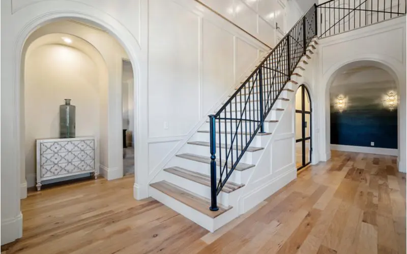 Wainscoting idea in the entryway painted white with tan wooden flooring