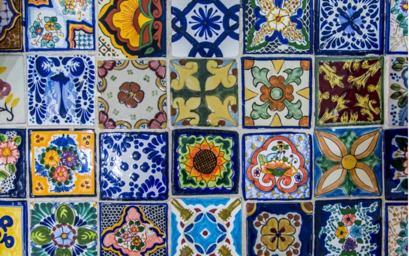 Pretty and colorful tiles laid out in a row to highlight a key design trait of Mexican kitchens
