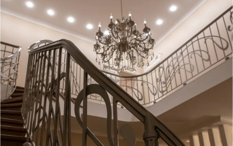 For a piece on stair trim ideas, a gorgeous metal patterned railing with metal stair trim runs up the side of a curved staircase