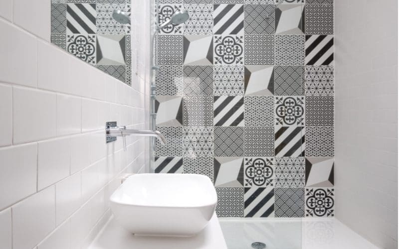 Open tile shower idea with black and white monochrome tiles on an accent wall with simple white subway tiles on the rest of the walls and floor