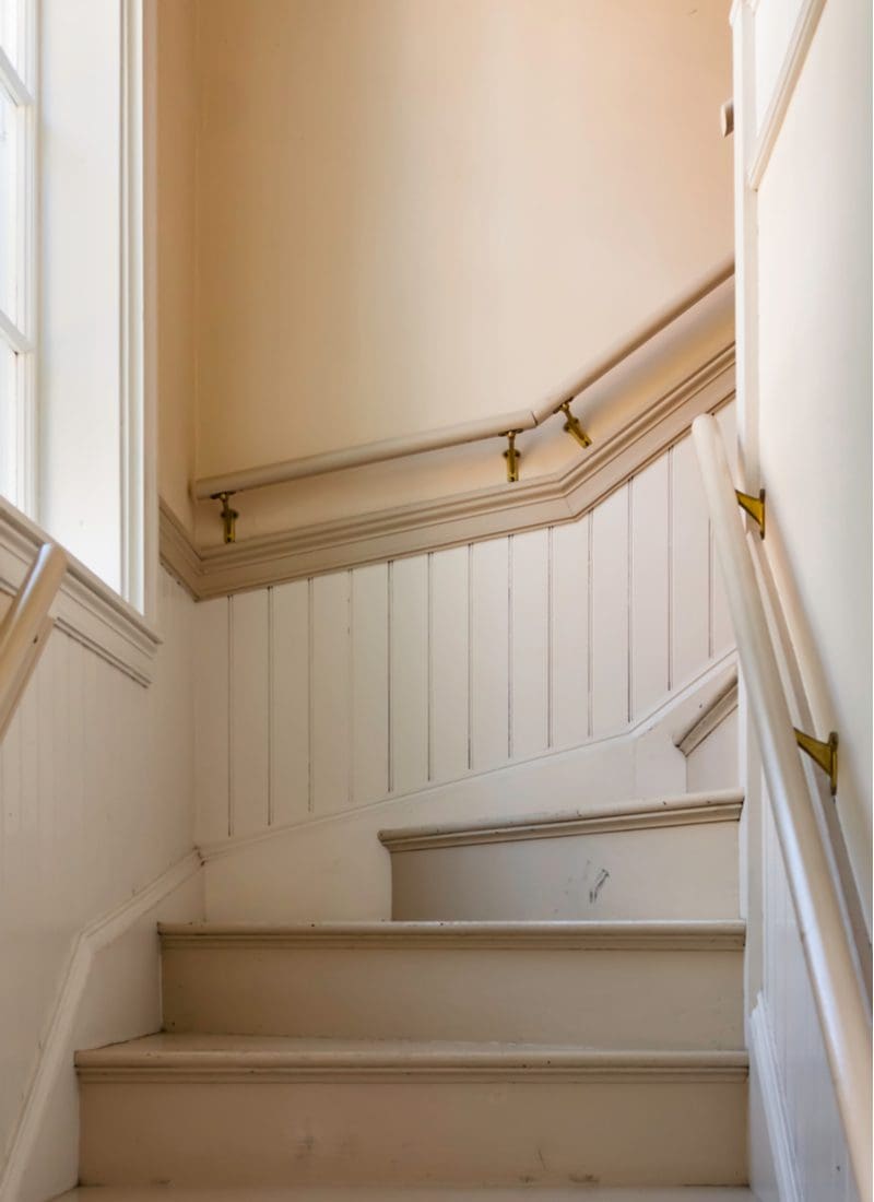 Wainscoting idea in a stairway with vertical molding halfway up the wall below the railing