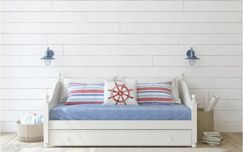 Nautical themed daybed in a shiplap-covered wall room for a piece on standard sofa sizes