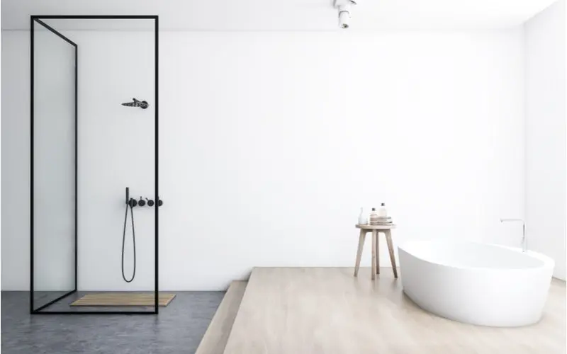 Contrasting color walk-in shower idea with white walls and light grey or brown tile below a raised tub next to the two-sided walk in shower with a rain showerhead