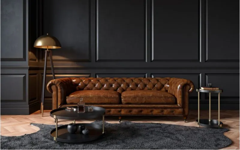 Dark brown couch living room idea with lots of near-black wainscoting and parquet wood flooring