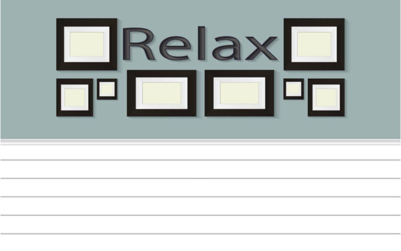 Shiplap style wainscoting idea in a graphic image below a sign that says relax with framed pictures around it