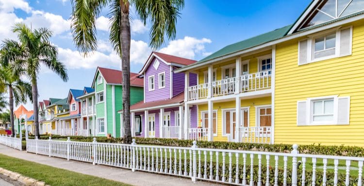 Various exterior house colors in blues, greens, yellows, and purples on a row of homes in the Dominican