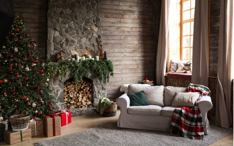 Dark living room with fireplace stocked with wood as viewed during the holiday season