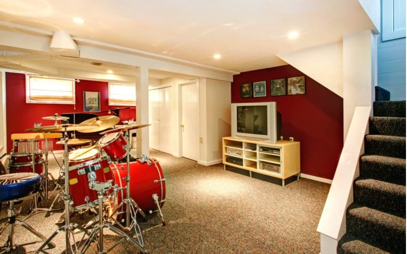 Basement idea with a music room with carpeted flooring and burgundy red walls