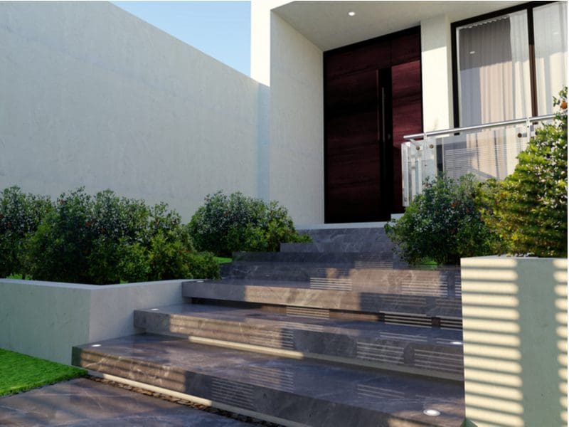 Ascending stair house entrance idea with floating marble steps leading to a grand stucco home entryway