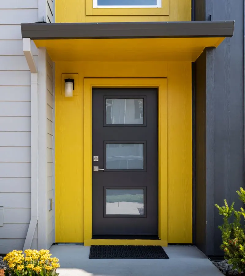 Bright orange house entrance idea with a three-panel horizontal glass door