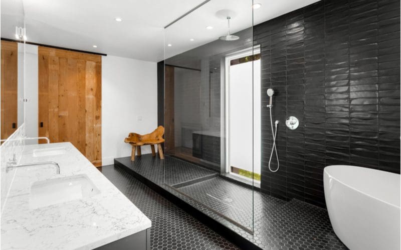 Frosted Glass and Natural Light with black tile and a white tub inside the shower