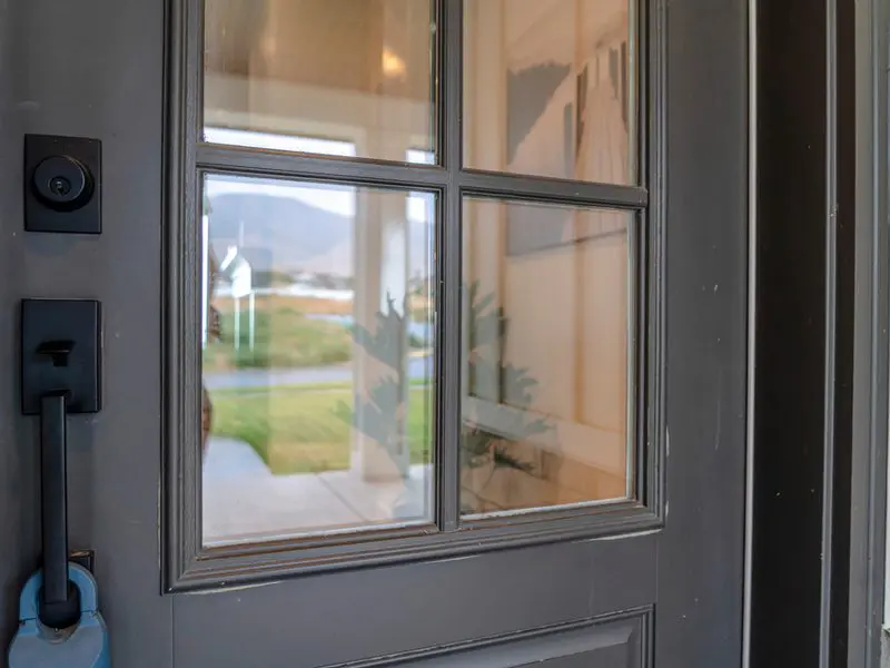 Dark grey multi-paneled windowed front door on a red brick house