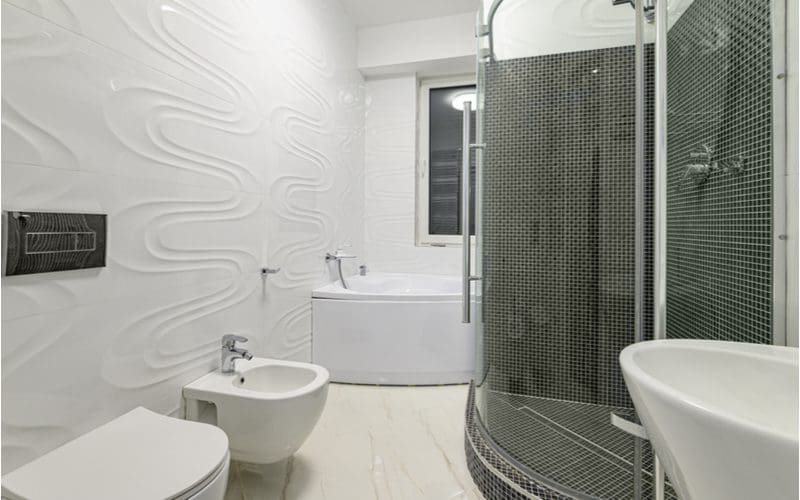 Modern luxury white and chrome bathroom with a round walk-in shower for a piece on walk-in shower ideas