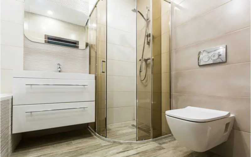 Graphic showing a non-standard size corner shower with a floating toilet and a floating vanity to represent a non-standard dimension