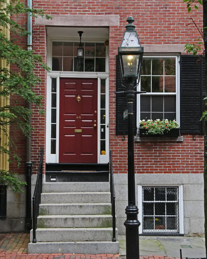 Brown painted front door on a red brick home in Boston with a nice looking lamppost outside