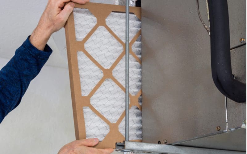 Guy taking out a filter for a piece on how often to change furnace filters