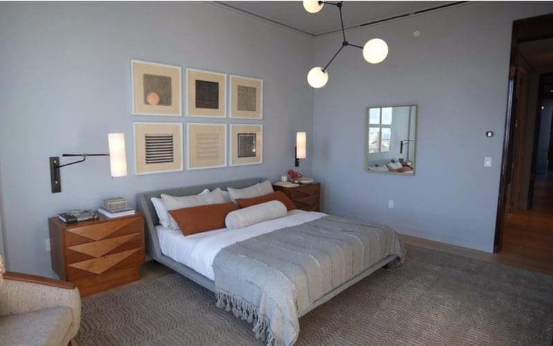 Image of an average sized apartment bedroom depicting a modern white rom with a white and grey bed