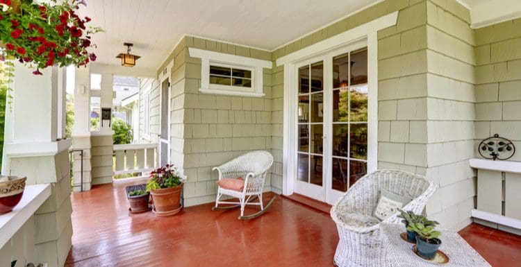 Featured image for a guide on French Door Sizes, a shake shingle old home with French doors leading out to a large covered patio