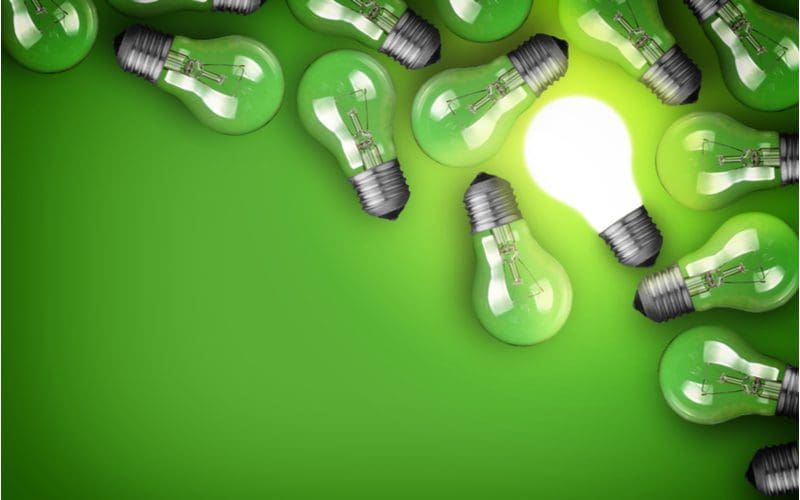Bunch of green light bulbs on a green background as an image for what does a green porch light mean