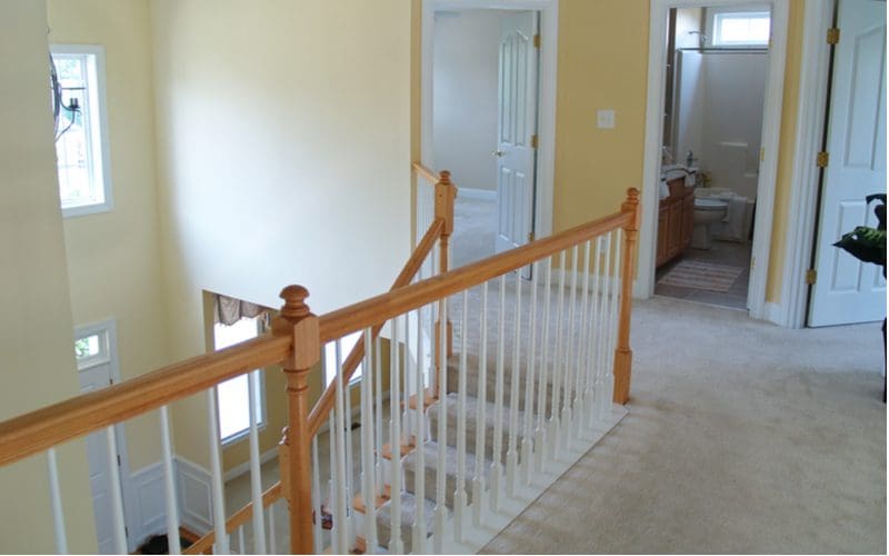 Stair trim ideas with an untrimmed staircase with a two-tone railing painted white