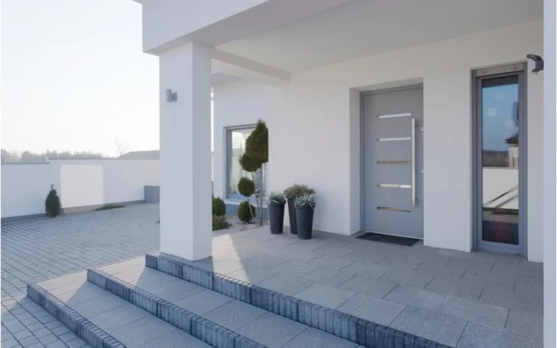 House entrance idea for a luxury home with steps that go up to a front door that's grey in color