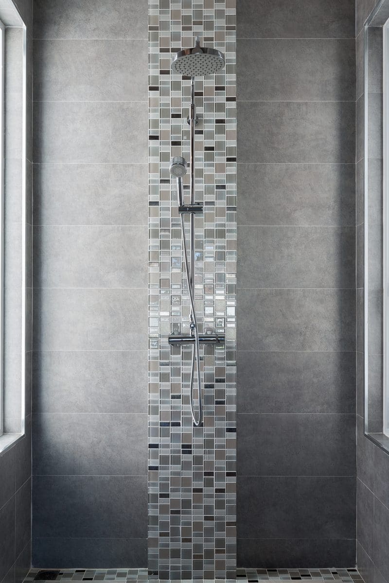 Grey tile bathroom idea with a simple square grey ceramic tile with glass mosaic tile running down the middle