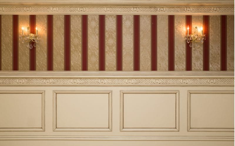 Formal and fancy wainscoting idea with striped wallpaper above white wooden paneling