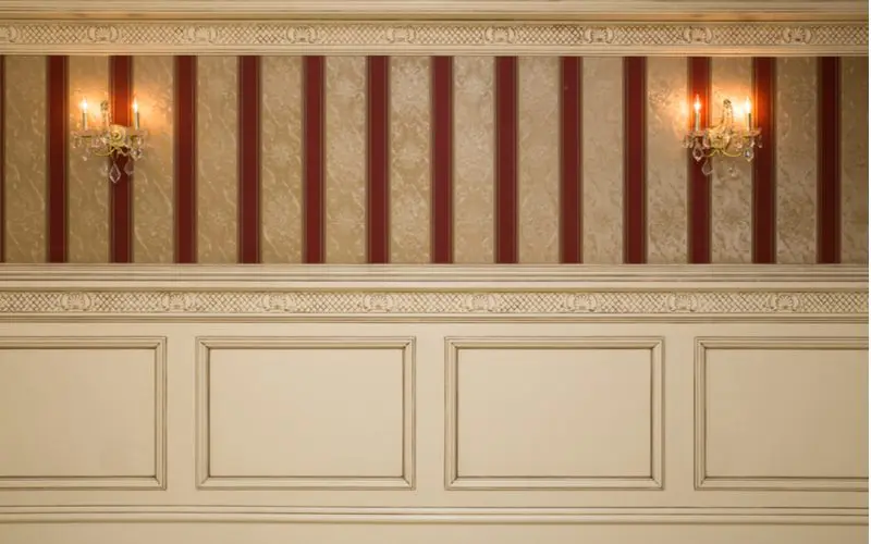 Formal and fancy wainscoting idea with striped wallpaper above white wooden paneling