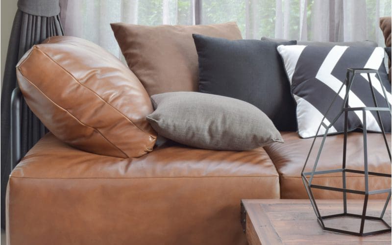 Dark brown couch living room idea to play with different textures and patterns of pillows